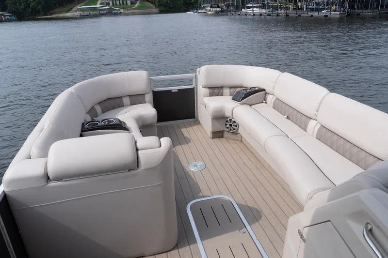 Slide: The Image of Luxurious seating on a 2017 Bennington R25 pontoon boat, docked on a serene lake. - 10
