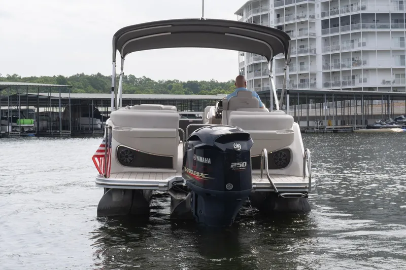 Slide: The Image of 2017 Bennington R25 pontoon boat with Yamaha 250 engine on a lake near docks. - 5