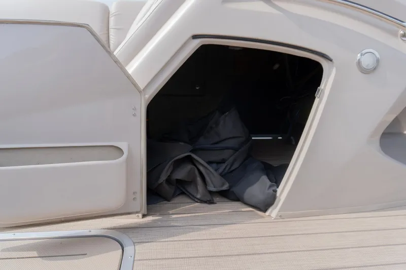 Slide: The Image of Open storage compartment on a 2017 Bennington R25 boat with fabric inside. - 20