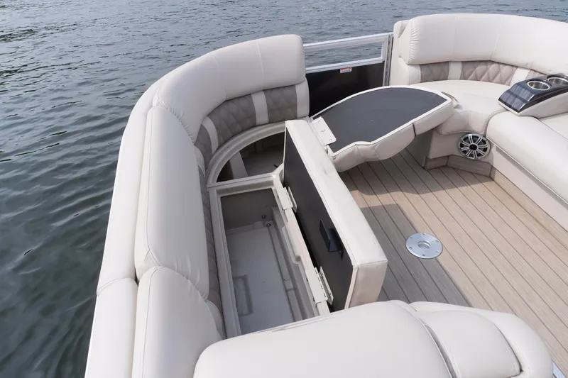 Slide: The Image of 2017 Bennington R25 pontoon boat interior with plush seating and storage compartment. - 12
