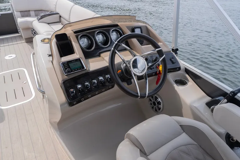 Slide: The Image of 2017 Bennington R25 boat dashboard with steering wheel and control panel on water. - 7