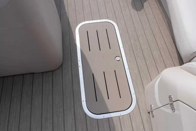 Slide: The Image of 2017 Bennington R25 boat deck with storage hatch, featuring sleek beige and gray design. - 18