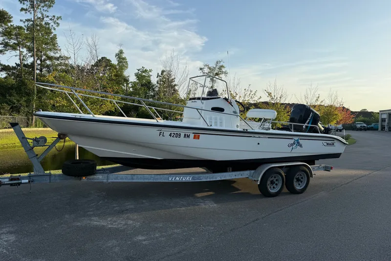 Slide: The Image of 2003 Boston Whaler 220 Dauntless boat on trailer, parked outdoors near trees. - 13