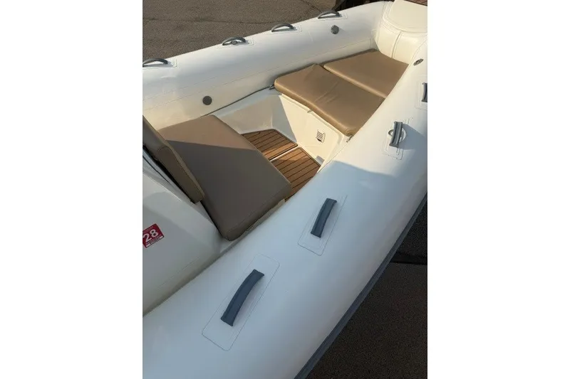 Slide: The Image of 2020 Brig Eagle 6.7 boat interior with cushioned seating and wooden flooring. - 2