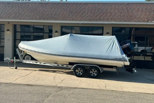 Slide: The Image of 2020 Brig Eagle 6.7 boat covered on trailer, parked outside a building. - 13