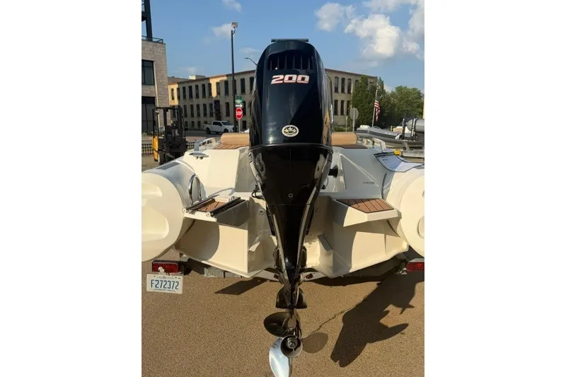 Slide: The Image of 2020 Brig Eagle 6.7 boat with a 200 HP outboard motor, parked outdoors. - 11