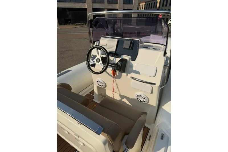 Slide: The Image of 2020 Brig Eagle 6.7 boat cockpit with steering wheel and control panel. - 6