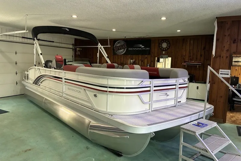 The Image of 2027 Bennington 22 SS pontoon boat in a showroom with red and gray seating. - 1