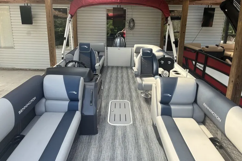 Slide: The Image of 2027 Bennington 22 SSR pontoon boat interior with gray and blue seating under a red canopy. - 7
