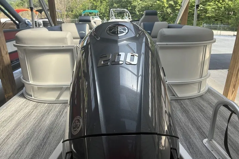 Slide: The Image of 2027 Bennington 22 SSR pontoon boat with powerful 200 HP engine, docked outdoors. - 4