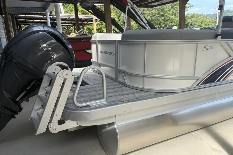 Slide: The Image of 2027 Bennington 22 SSR pontoon boat with Yamaha outboard motor, docked under a shelter. - 5