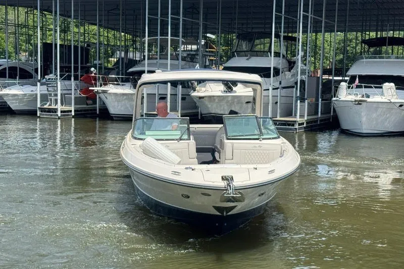 Slide: The Image of 2022 Sea Ray SLX 310 boat docked at marina, surrounded by other vessels. - 1