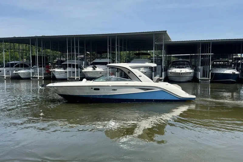 The Image of 2022 Sea Ray SLX 310 boat docked at marina, surrounded by other boats. - 0
