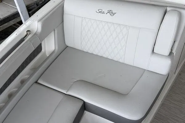 Slide: The Image of 2022 Sea Ray SLX 310 boat interior with white cushioned seating and elegant stitching. - 11