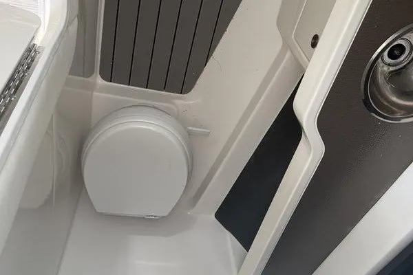 Slide: The Image of Interior view of a 2022 Sea Ray SLX 310 boat, featuring a compact marine toilet. - 15