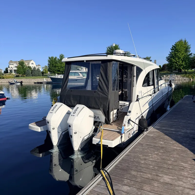 Slide: The Image of The 2025 Beneteau Antares 11 is docked at a calm pier with two outboard engines. - 39