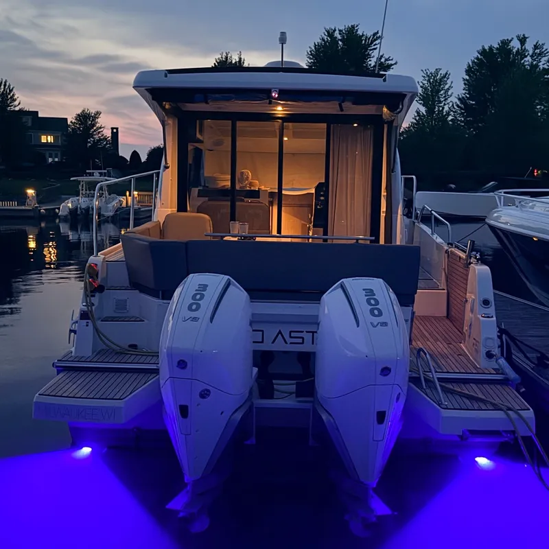 Slide: The Image of The 2025 Beneteau Antares 11 is docked, illuminated by blue lights, featuring twin outboard engines. - 40
