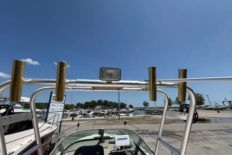 Slide: The Image of Bayliner 2002 Trophy Walkaround boat with rod holders at marina under clear blue sky. - 17
