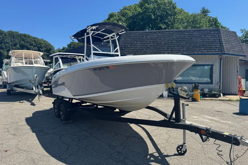 Slide: The Image of 2023 Wellcraft 202 Fisherman boat on trailer, parked outdoors near a building. - 3