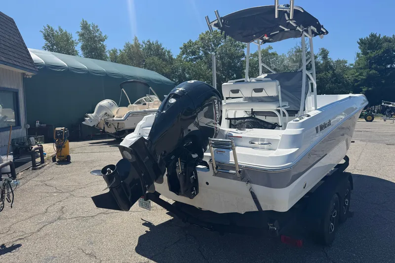 Slide: The Image of 2023 Wellcraft 202 Fisherman boat with outboard motor on trailer in sunny marina. - 4