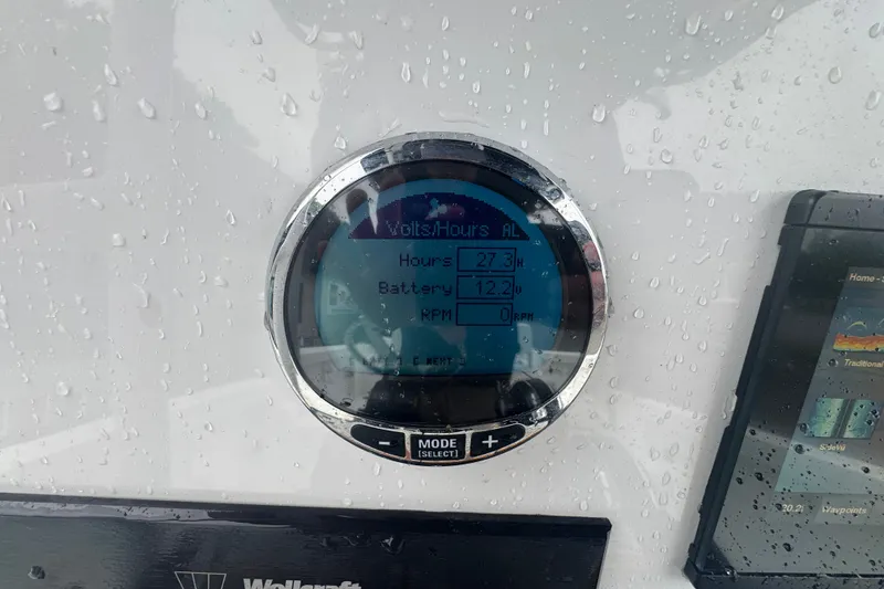 Slide: The Image of Digital display on 2023 Wellcraft 202 Fisherman boat, showing battery voltage and hours. - 9