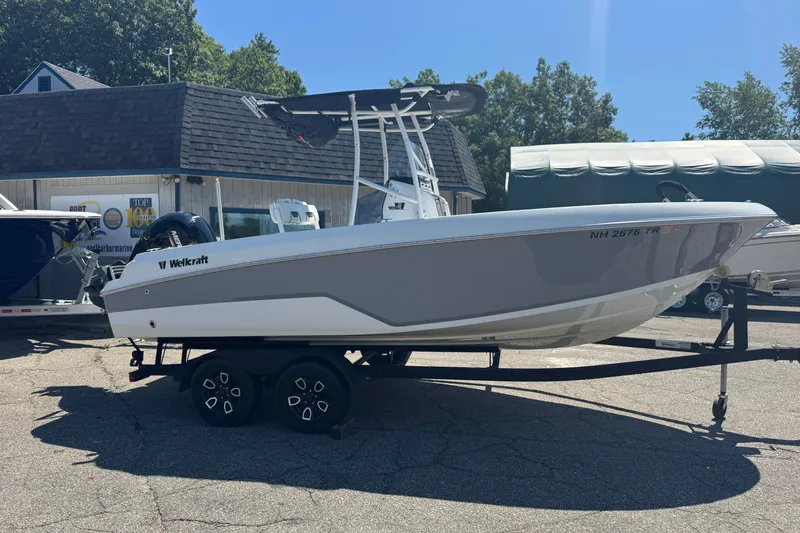 Slide: The Image of 2023 Wellcraft 202 Fisherman boat on trailer, parked outdoors in sunny weather. - 2
