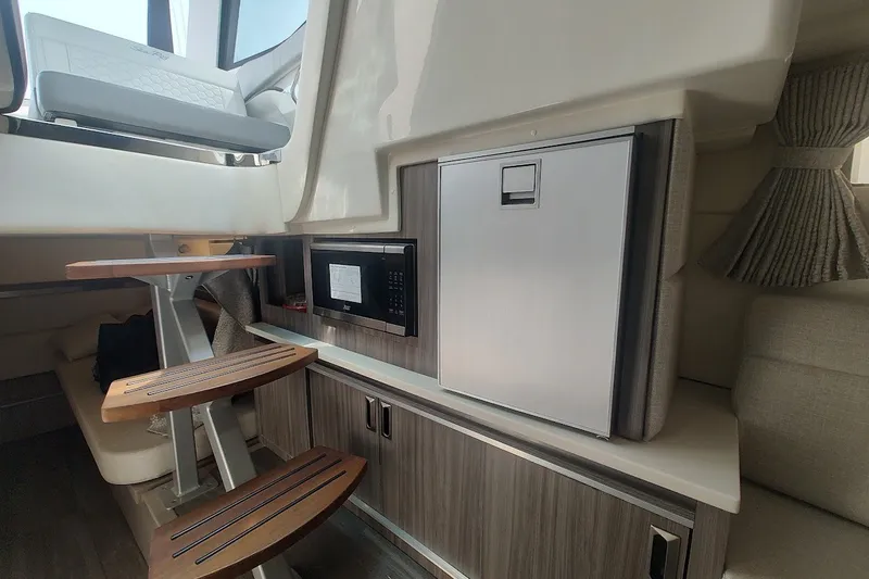 Slide: The Image of 2024 Sea Ray Sundancer 320 Coupe interior with kitchenette and seating area. - 31