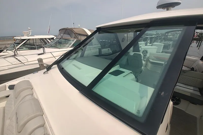 Slide: The Image of 2024 Sea Ray Sundancer 320 Coupe docked, showcasing sleek design and spacious interior. - 24