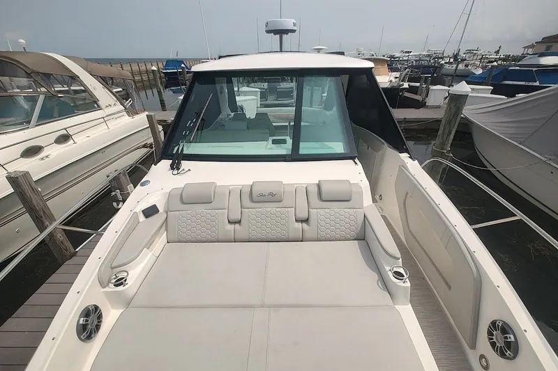 Slide: The Image of 2024 Sea Ray Sundancer 320 Coupe at marina, showcasing spacious deck and modern design. - 25
