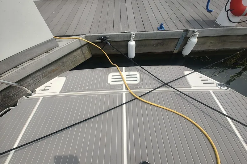 Slide: The Image of 2024 Sea Ray Sundancer 320 Coupe docked, showing swim platform with power cables and fenders. - 13