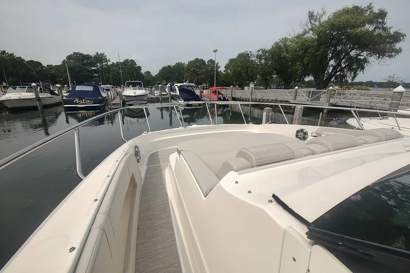 Slide: The Image of 2024 Sea Ray Sundancer 320 Coupe docked at marina, showcasing sleek design and spacious deck. - 29