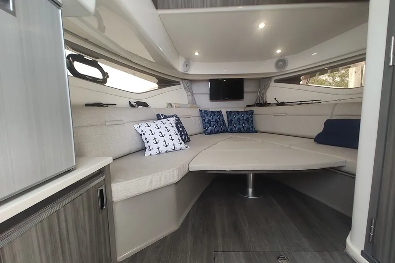 Slide: The Image of 2024 Sea Ray Sundancer 320 Coupe interior with cozy seating and nautical-themed pillows. - 34
