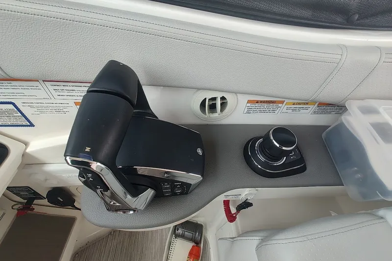 Slide: The Image of 2024 Sea Ray Sundancer 320 Coupe cockpit controls with joystick and throttle. - 20