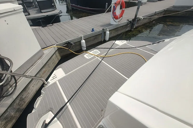 Slide: The Image of 2024 Sea Ray Sundancer 320 Coupe docked, showcasing swim platform and marina setting. - 16