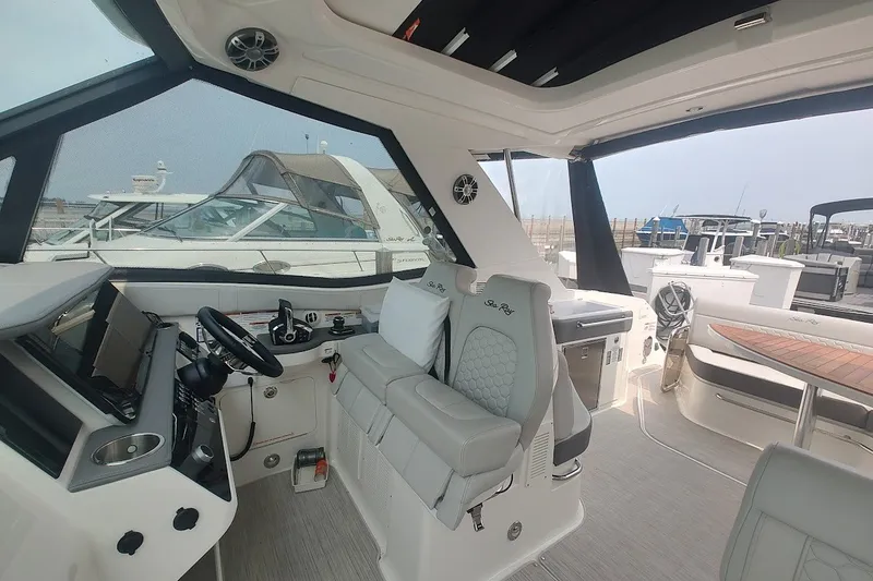 Slide: The Image of 2024 Sea Ray Sundancer 320 Coupe interior with helm, seating, and modern design. - 21