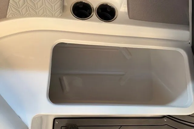Slide: The Image of 2026 Hurricane SunDeck 2400 OB boat interior with cup holders and storage compartment. - 17
