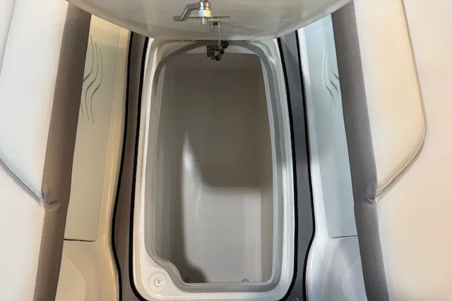 Slide: The Image of 2026 Hurricane SunDeck 2400 OB boat storage compartment with open lid and seating. - 13