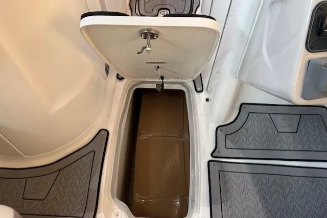 Slide: The Image of 2026 Hurricane SunDeck 2400 OB boat storage compartment with open hatch and non-slip flooring. - 14