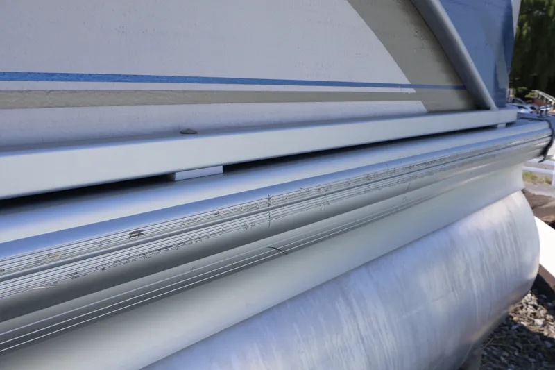 Slide: The Image of Close-up of 2008 Premier 210 Sunsation pontoon boat with visible wear on the side. - 8
