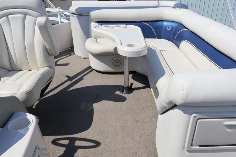 Slide: The Image of 2008 Premier 210 Sunsation boat interior with white and blue seating and table. - 20