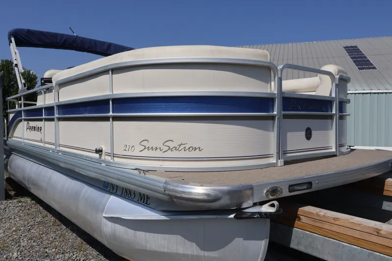 Slide: The Image of 2008 Premier 210 Sunsation pontoon boat with blue accents, docked outdoors. - 10