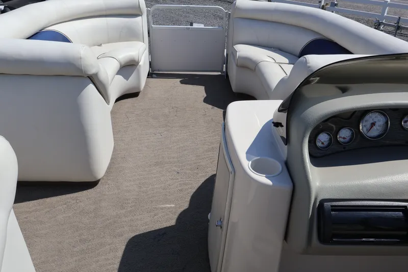 Slide: The Image of Interior of a 2008 Premier 210 Sunsation pontoon boat with plush seating and dashboard gauges. - 49