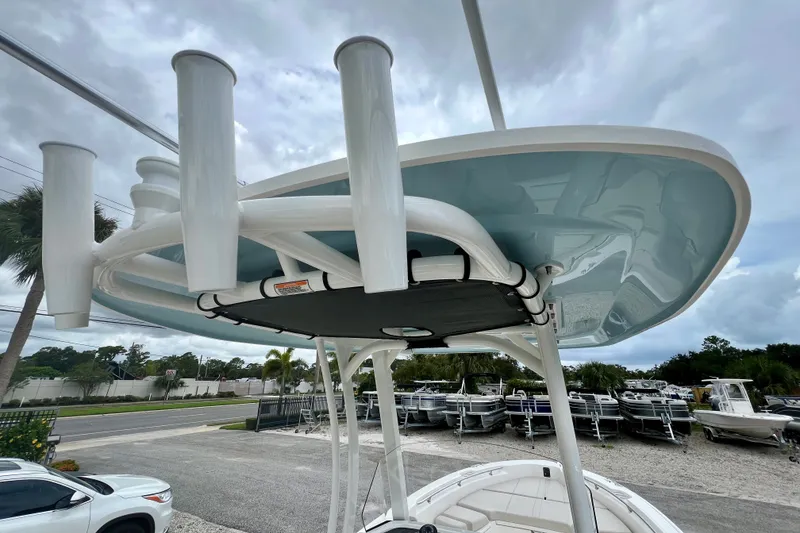 Slide: The Image of 2026 Boston Whaler 250 Dauntless boat with rod holders and sleek design under cloudy sky. - 19