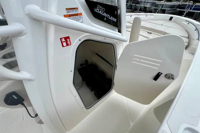 Slide: The Image of 2026 Boston Whaler 250 Dauntless storage compartment with open door, showcasing interior space. - 27