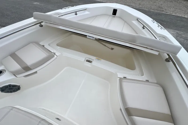 Slide: The Image of 2026 Boston Whaler 250 Dauntless boat interior with cushioned seating and storage compartment. - 34