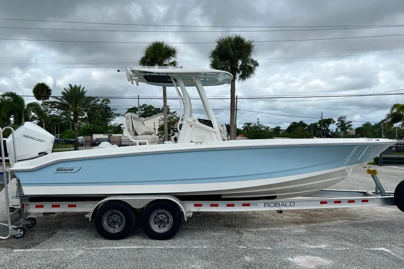 The Image of 2026 Boston Whaler 250 Dauntless boat on trailer, parked outdoors under cloudy sky. - 1