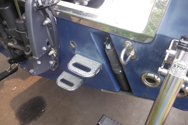 Slide: The Image of Rear view of a 2006 Southport 26 Center Console boat with metal steps and engine components. - 12