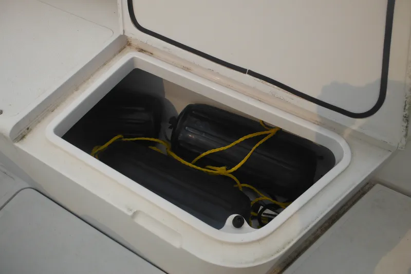 Slide: The Image of Storage compartment with black fenders on a 2006 Southport 26 Center Console boat. - 21