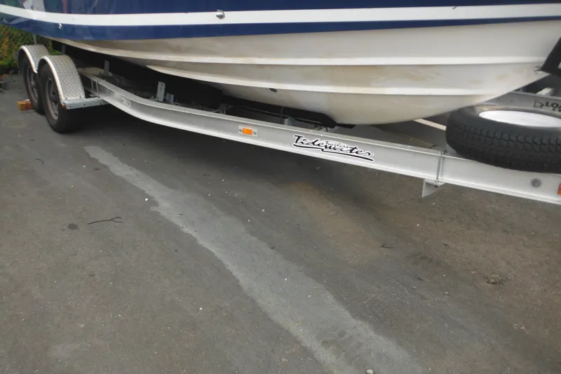 Slide: The Image of 2006 Southport 26 Center Console boat on Tidewater trailer, parked on asphalt. - 2