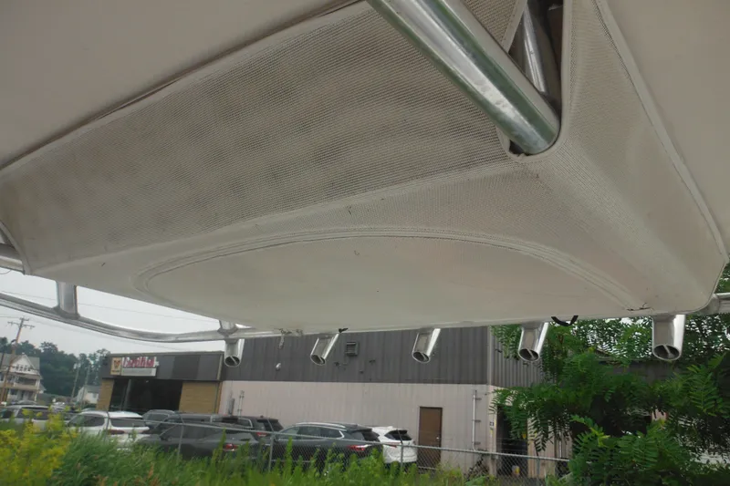 Slide: The Image of 2006 Southport 26 Center Console boat canopy with rod holders, parked near a building. - 45
